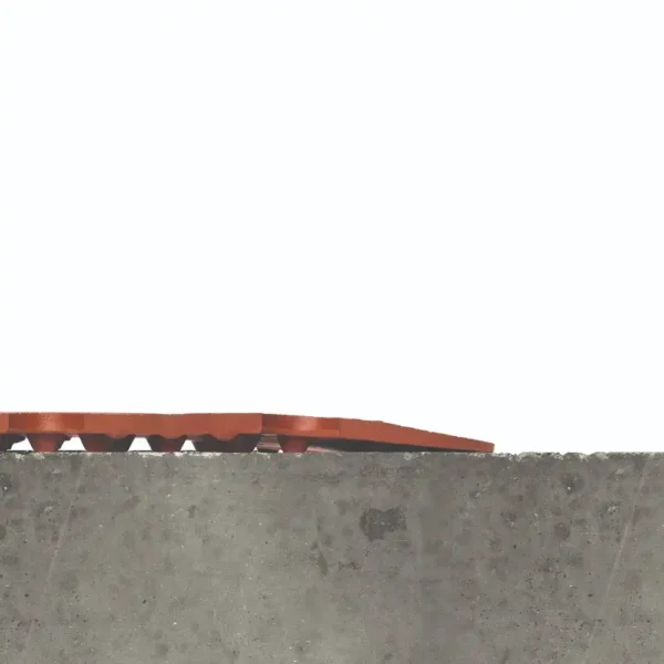 A red Food Production Mat with a wavy texture lies unevenly on the edge of a grey concrete surface against a plain white background.
