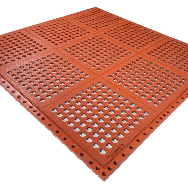 The Interlocking Catering Mat is a large, red, square mat with raised truncated domes and round holes in a grid pattern, designed to guide visually impaired pedestrians.