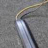 Two cables, one yellow and one black, are enclosed by a PVC Cable Protector (Data) on a grey textured carpet.