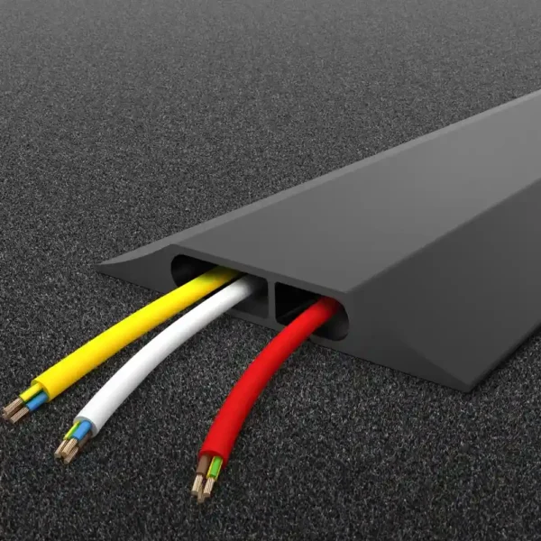 A PVC Cable Protector (Data) in black lies on dark carpet, with yellow, white, and red wires organised inside its two channels, partially visible at the open end.