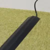 A PVC Cable Protector (GP) lies flat on light green carpet, neatly concealing a black lead as it runs towards a white wall.