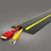 A PVC Cable Protector (GP) in black and yellow covers a red HDMI cable and a yellow Ethernet cable on a grey surface.