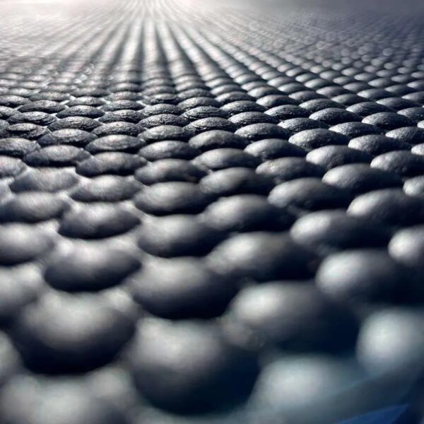 Close-up of the Cobble Top Stable Mat’s textured black surface featuring evenly spaced, raised circular bumps; the foreground is sharp and detailed whilst the pattern gently blurs into the background.