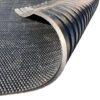 Close-up of the Cobble Top Stable Mat, featuring a black rubber, textured non-slip surface. One corner is curled up to show the ridged underside for extra grip.