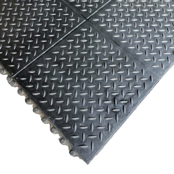 Close-up of the Interlocking Checker Plate Gym Mat, featuring black rubber mats with a chequer plate texture and puzzle-like connecting edges.