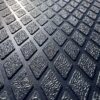 Close-up of the Diamond Top Stable Mat, showcasing its textured rubber surface with a repeating pattern of raised diamond shapes arranged in neat rows under bright lighting.