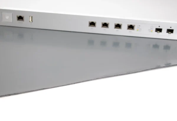 A close-up of an ESD Anti-Static Double Layer Sheet beneath a silver network switch with multiple Ethernet and USB ports, displayed on a reflective grey surface.