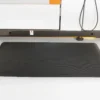 A Fine Ribbed Anti-Fatigue Mat in rectangular black is placed on a light-coloured floor before industrial equipment, with cables and a metal support bar visible in the background.