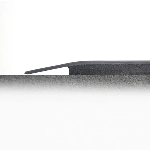 Side view of a Fine Ribbed Anti-Fatigue Mat installed between two flooring surfaces of different heights, highlighting its sloped design for a smooth transition.