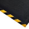 The Foam Cushioned Industrial Mat is a black rubber safety mat with a textured surface and a yellow-black striped border, pictured from a diagonal angle.