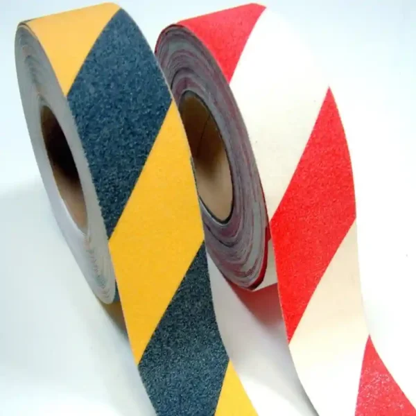 Two upright rolls of GRP Grit Tape—one yellow/black striped, the other red/white striped—are shown against a plain white background.