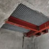 An Angle Profile is installed in a concrete ceiling, supported by red steel beams in a cross pattern. The surrounding concrete displays rough edges where the Angle Profile was fitted.