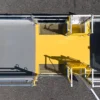 Aerial view of a yellow and grey metal industrial walkway featuring Anti-Slip Flat Sheet panels with grated and solid flooring, safety railings, gates, and set on a tarmac surface.