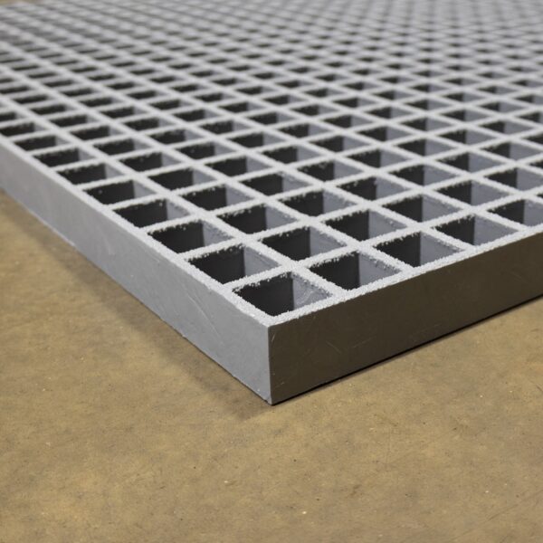 A close-up of the Open Top Grating shows its metallic grey finish and grid pattern with square openings, placed on a concrete floor.