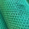 Close-up of stacked Grass Mat Underlay Mesh in turquoise, featuring a hexagonal pattern. The slightly bent and layered mesh highlights its texture, depth, and geometric repetition.