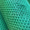 Close-up of Grass Mat Underlay Mesh in green plastic, featuring a repeating hexagonal pattern with multiple overlapping layers for a textured, lattice-like appearance.