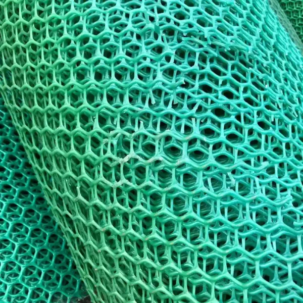 Close-up of Grass Mat Underlay Mesh in green plastic, featuring a repeating hexagonal pattern with multiple overlapping layers for a textured, lattice-like appearance.