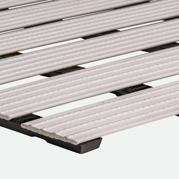 Close-up of the Cross-Ribbed PVC Leisure Mat featuring parallel, ribbed white planks supported by a dark frame, photographed against a plain white background.