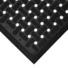 Close-up of a Nitrile Workplace Mat corner showing its black rubber surface with a textured pattern of raised horizontal bars and round holes for slip-resistance and drainage.