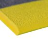 Close-up of the Standard Anti-Fatigue Mat in yellow, featuring a textured surface and bevelled edge, resting on a grey surface. The mat is constructed from durable foam material.