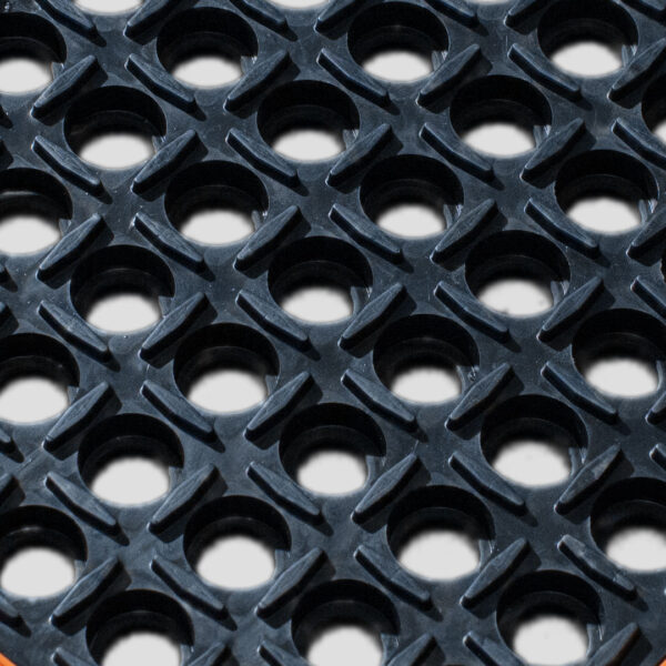 Close-up of the Custom Oil Resistant Mat, featuring a black rubber surface with a diamond-textured grid and circular holes for drainage and anti-slip functionality.