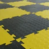 Close-up of Circular Stud Interlocking Tiles in a yellow and black chequerboard pattern, each tile featuring a raised circular stud texture for enhanced grip and traction.