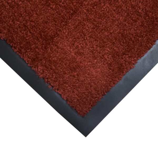 Close-up view of the corner of the Plush Entrance Mat, featuring red shaggy fibres with a black border, displayed on a white background.