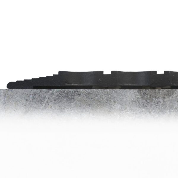 Close-up side view of the Large Front Door Mat Bundle, featuring a textured black rubber surface with a wavy pattern, resting on grey concrete against a white background.