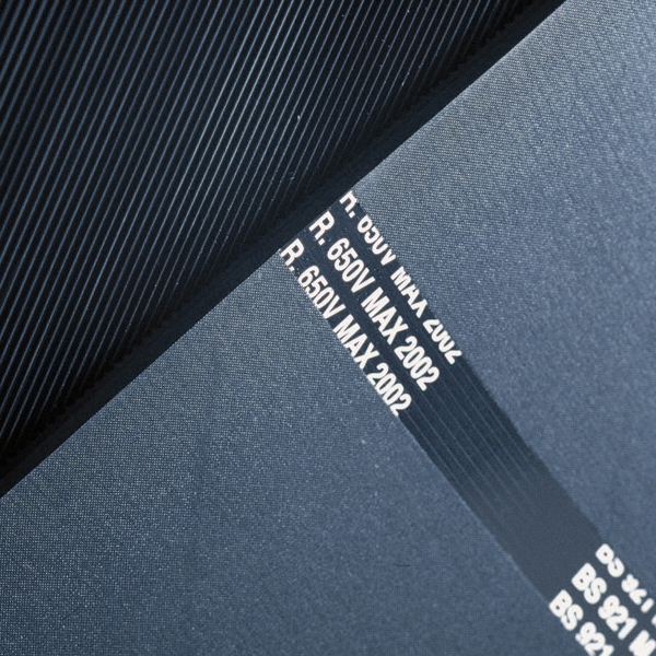 Close-up of Electrical Insulation Matting in dark blue with a ridged texture and white printed text, including "R: 650V MAX 2002," shown on a flat, smooth surface.