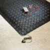 A Senso Dial Mat ESD, a black textured heating mat with digital thermostat and wires, is placed partly on a tiled floor with its power plug and lead nearby.