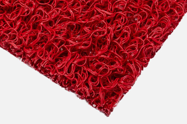 Close-up of the corner of a red Heavy-Duty PVC Vinyl Roll doormat, featuring a textured, tangled looped plastic design on a white background.