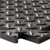 Close-up of a Chequer Plate Interlocking Tile, featuring a black rubber surface with a raised diamond pattern, leaf-shaped grips, and an interlocking edge design.