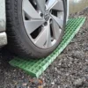 A car tyre rests on Waffle Boards traction mats placed on gravel, likely to help the vehicle gain grip on the uneven surface.
