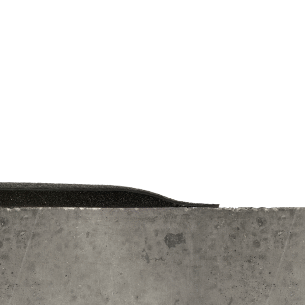 A close-up side view of the Welding Anti-Fatigue Mat’s rough concrete-like surface with a thin black rubber strip along the top edge, set against a white background.