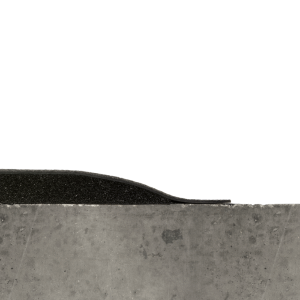 Cross-section of a concrete slab with the Welding Anti-Fatigue Mat, featuring a black foam or rubber layer on top, highlighting the contrasting textures and materials.