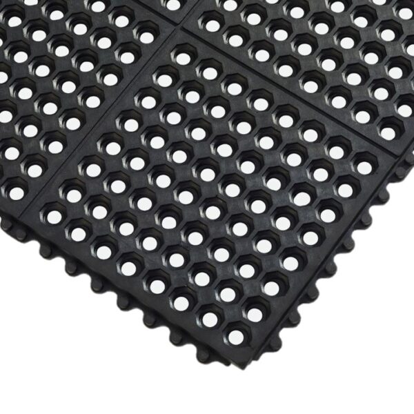 The Interlocking Anti-Fatigue Mat is made of black rubber featuring a grid pattern of large circular holes and raised edge bumps, displayed from an angled top-down view.