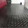 A close-up of Chequer Plate Rubber Matting shows its textured diamond pattern, ideal for industrial or workshop flooring. Equipment appears in the background.