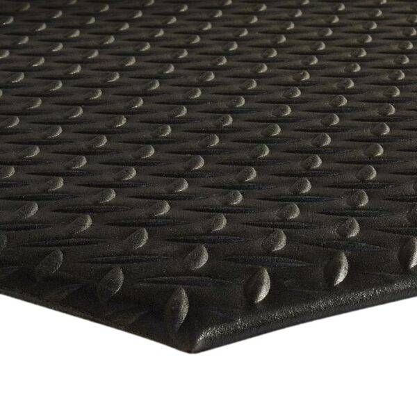 Close-up of the Comfort Plus Anti-Fatigue Mat in black rubber, featuring a raised diamond pattern texture photographed at an angle to highlight its repeating three-dimensional surface design.