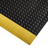 The Comfort Plus Anti-Fatigue Mat, shown from an angled top view, features a black diamond plate surface for grip and a yellow bevelled edge that acts as a high-visibility safety border.