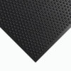 A close-up of the corner of a Stable Matting Bundles black rubber mat featuring raised, evenly spaced circular bumps on its surface.