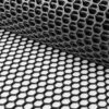 A close-up of Grass Mat Underlay Mesh, partially unrolled on a flat surface. Its hexagonal pattern, resembling a honeycomb, is highlighted by light and shadows that accentuate the mesh’s 3D texture.