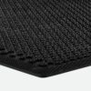 Close-up of the Dirt Remover Mat, a black rubber mat featuring a textured, raised circular pattern, displayed at an angle against a white background.