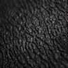 Close-up of the Standard Anti-Fatigue Mat's textured black surface, featuring deep, irregular grooves and a slightly shiny finish that resembles leather or skin.