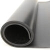 A close-up view of Black Commercial Rubber rolled up, highlighting its smooth surface and tightly coiled edge.