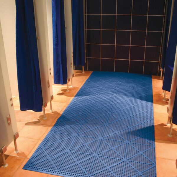 Interlocking Anti-Slip Leisure Tiles in blue are laid on the floor between rows of shower cubicles with blue curtains and orange tiles, leading to a black tiled wall at the back.