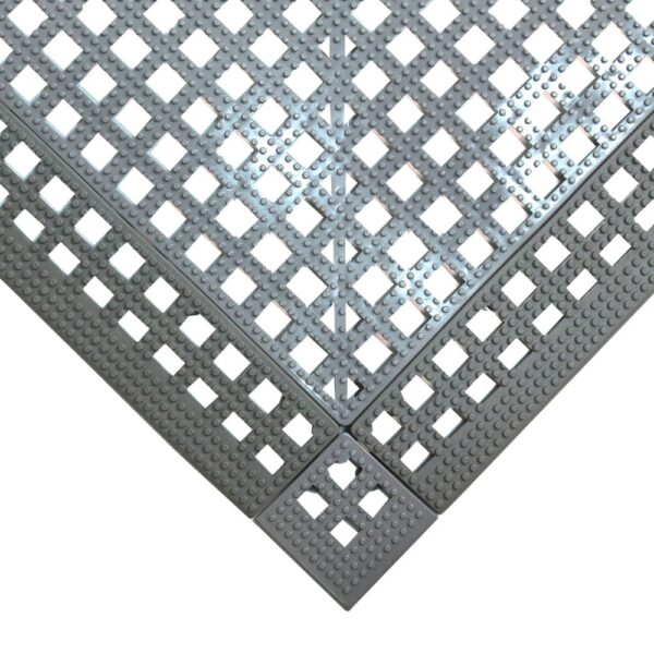 A close-up of Interlocking Anti-Slip Leisure Tile panels joined at a right angle, forming a corner with a chequered pattern of square holes.