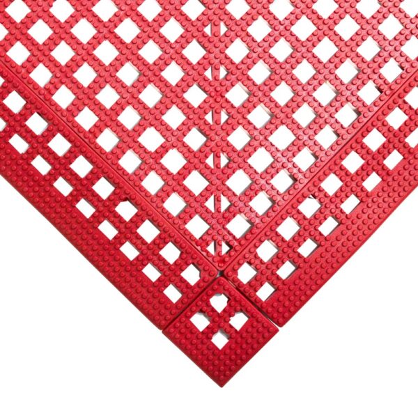Close-up view of a red Interlocking Anti-Slip Leisure Tile, featuring a grid of square holes at a right-angle corner. The tile’s surface is textured with small raised dots for added slip resistance.
