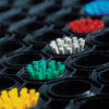 Close-up of an Octagonal Ring Mat featuring textured black material and clusters of yellow, green, white, red, and blue bristles arranged in octagonal openings. The image highlights the vibrant bristles in the foreground.