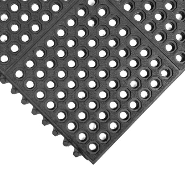 The Drainage Top Interlocking Mat is a black rubber floor mat with a grid of circular holes for anti-slip and drainage. Visible interlocking edges are located on the left and bottom sides.