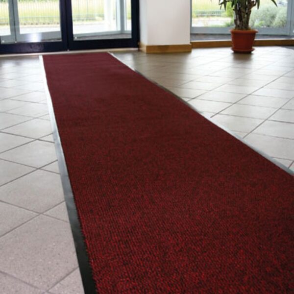 A Hard-Wearing Multi-Purpose Mat is laid out in the centre of a tiled floor in a bright room with large windows and a potted plant in the corner.